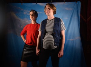 Lucia holds hands with Catherine, who is pregnant, as they look out into the distance.